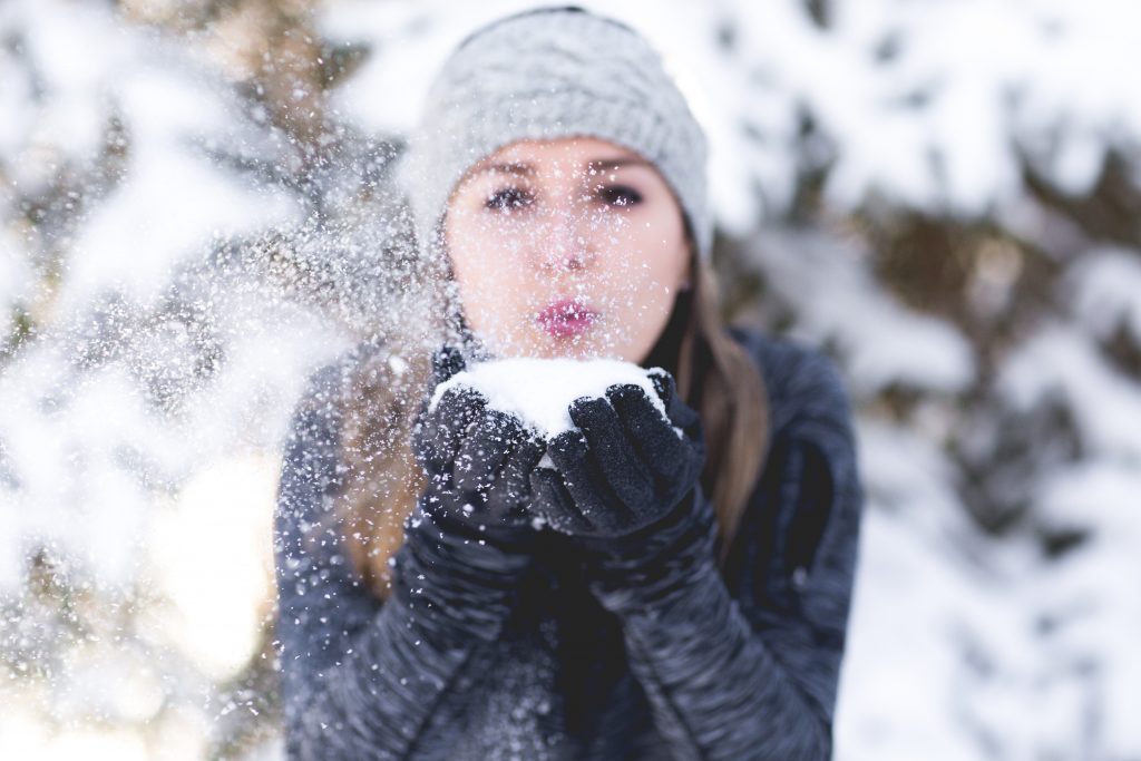 lady blowing snow from her hands